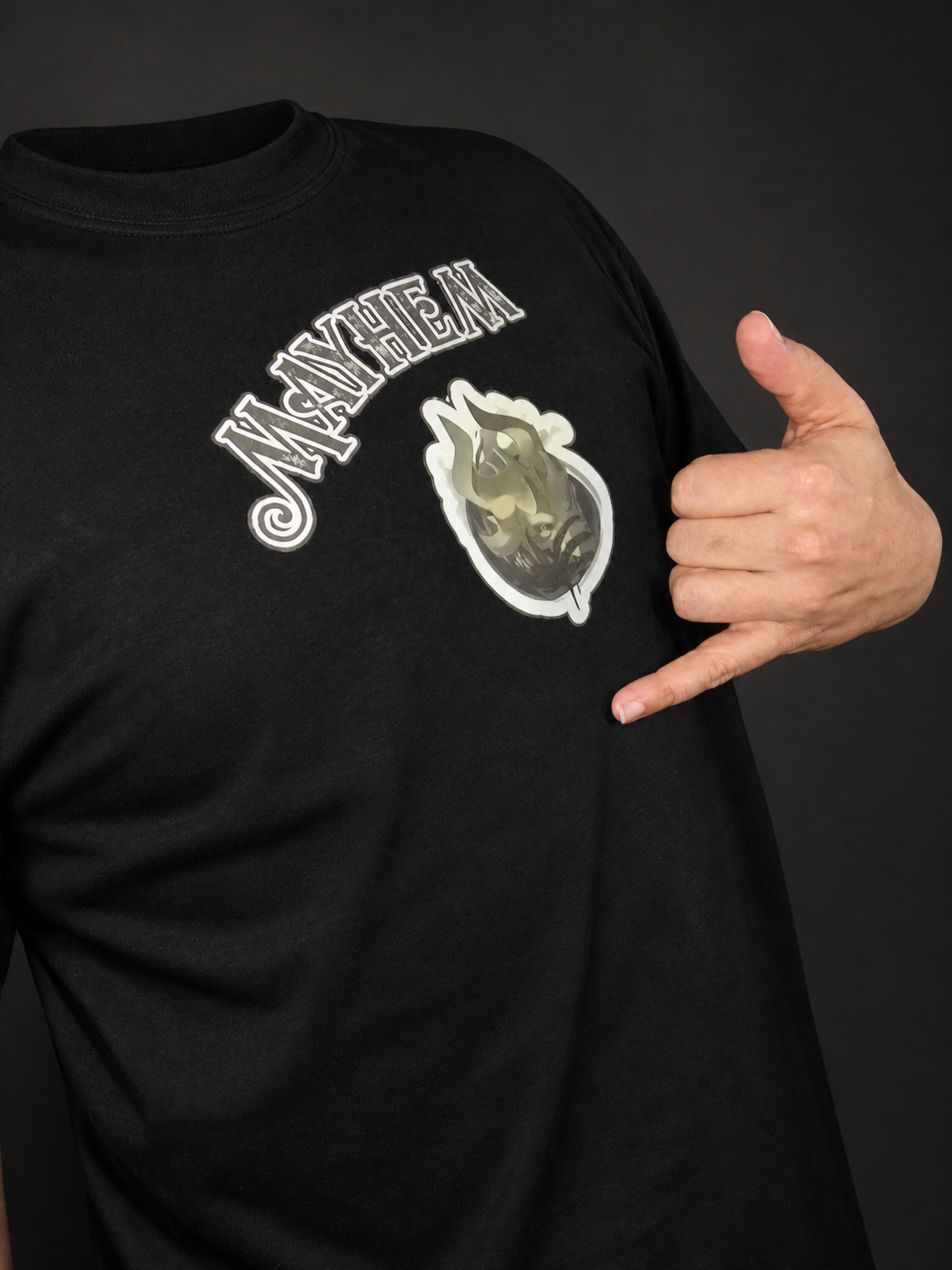 Clean product-focused photograph of the Mayhem shirt and hand gesture