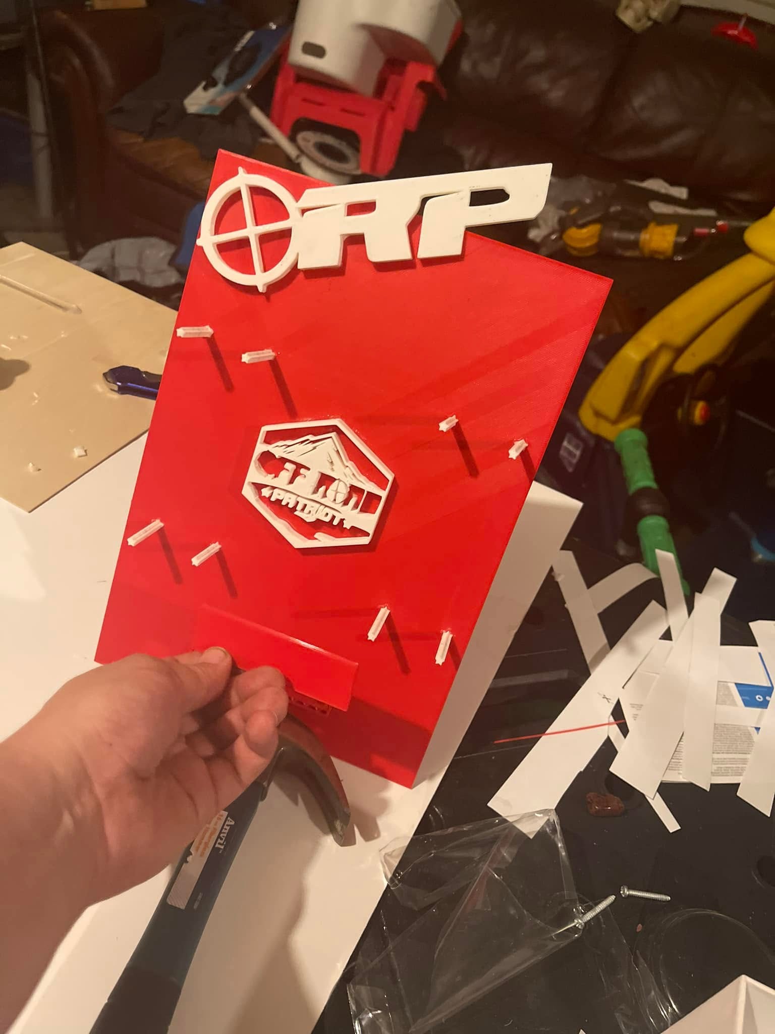 Red fabricated prototype held in hand during a fit check